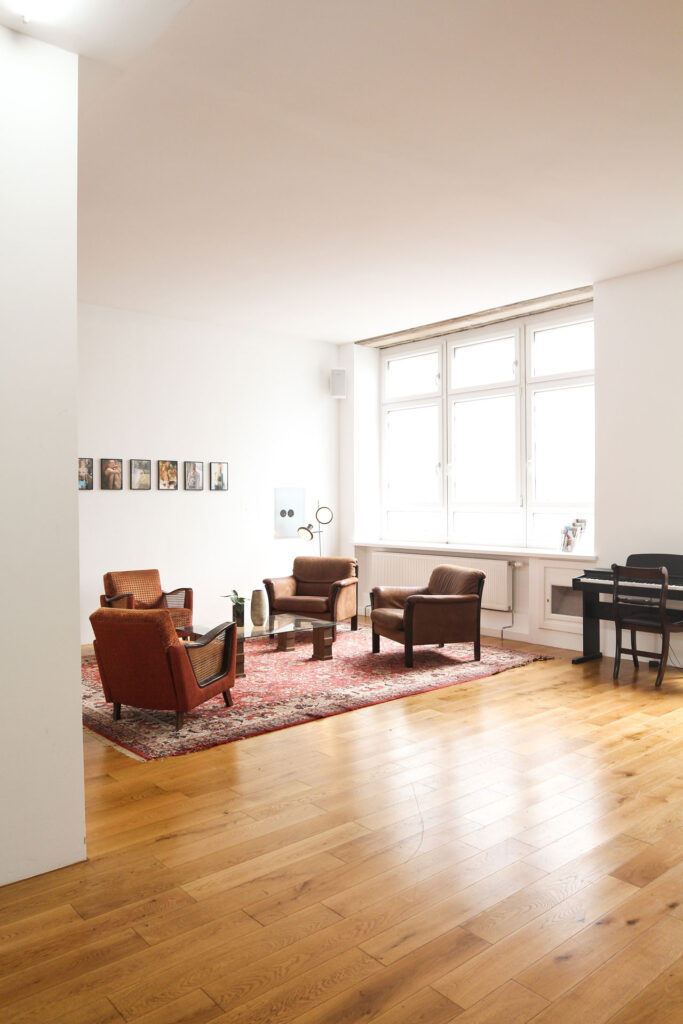 wood floors in living area with four couch chairs