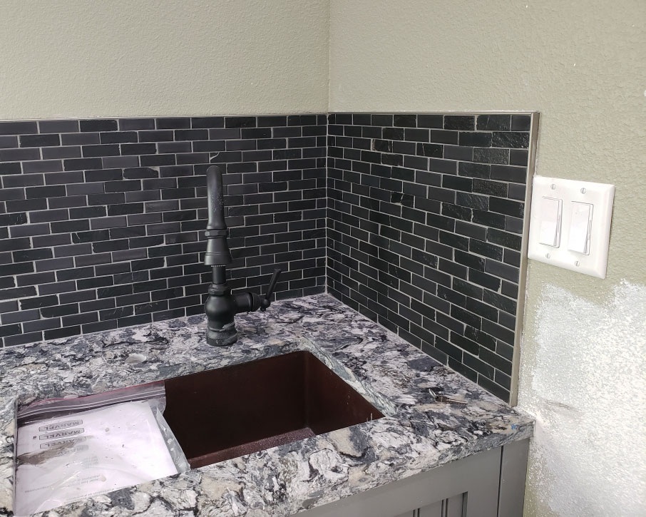 Kitchen counter with black wall splash tiles