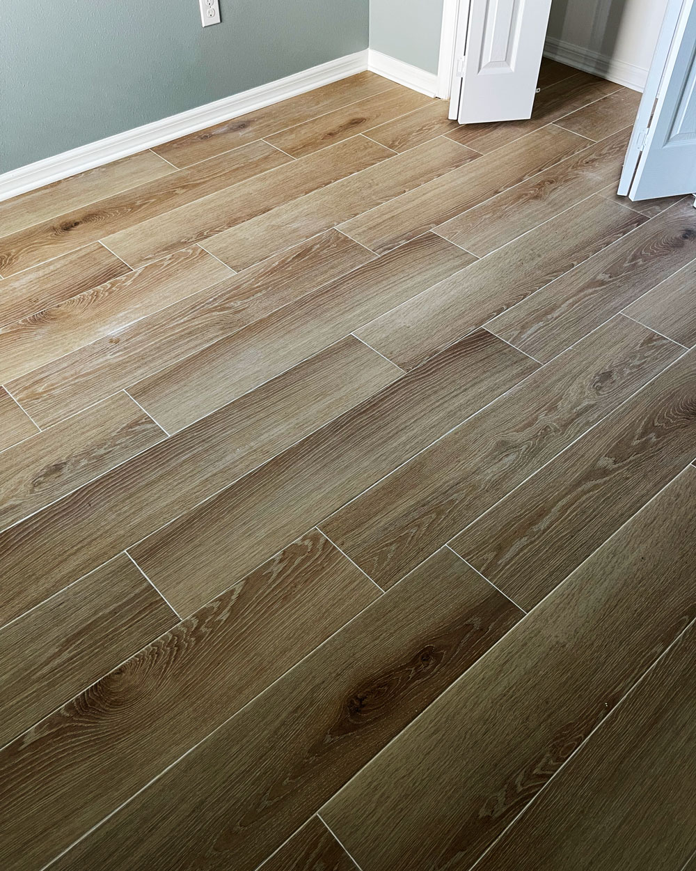 Bedroom with hardwood tile planks and white grout