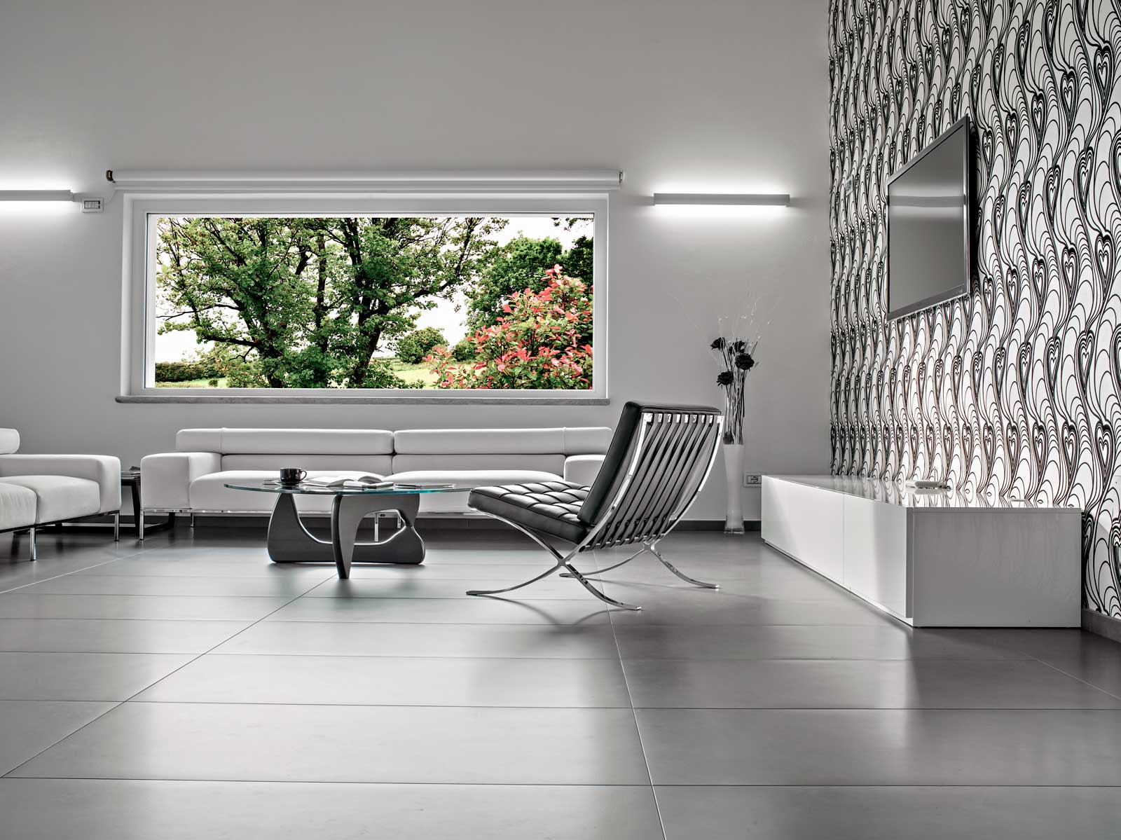 Interior of a modern living room with a large window and large grey tiles