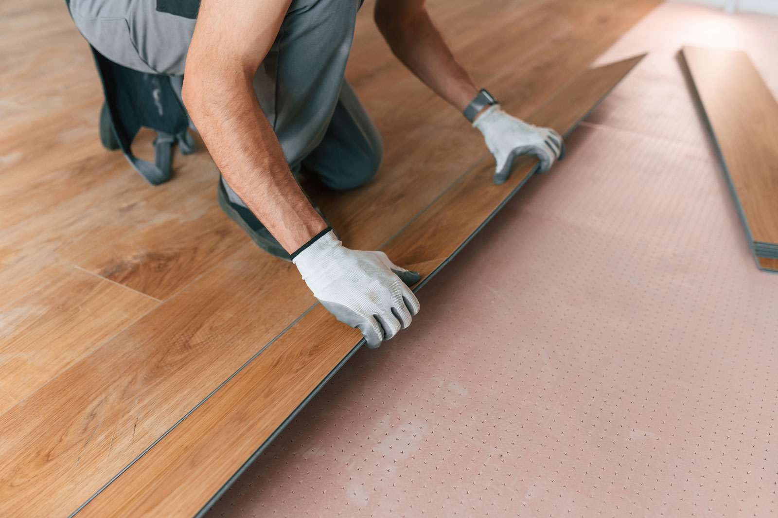 Worker installing new laminated wooden floors
