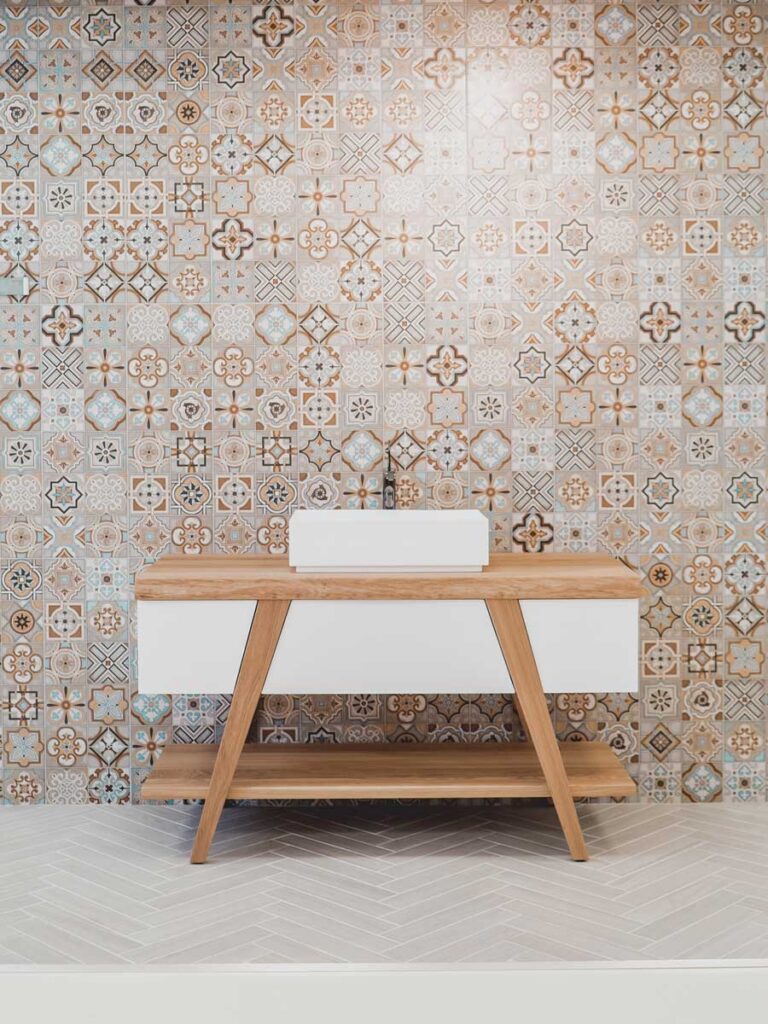 Mosaic tiled bathroom with patterned walls and chevron floor tiles