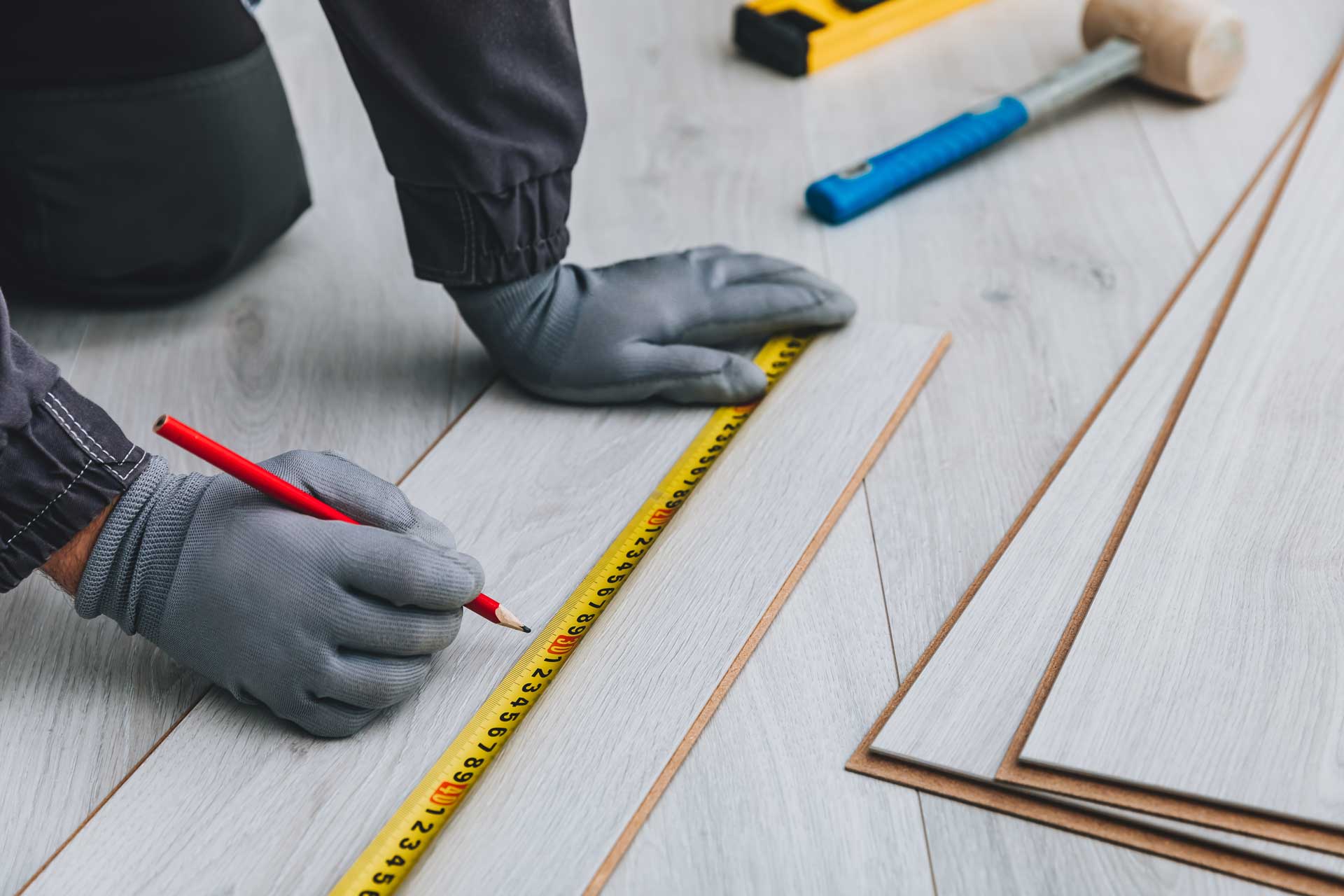 Worker measuring grey luxury vinyl planks